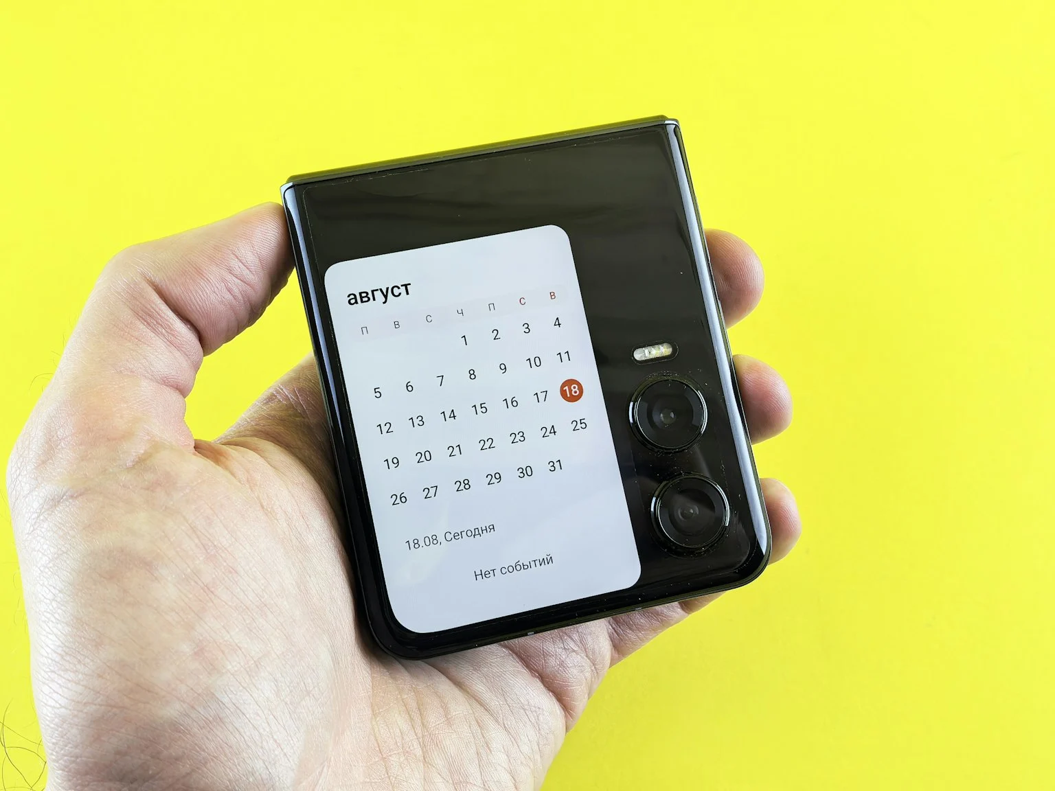 Een hand houdt een telefoon met een kalender vast.