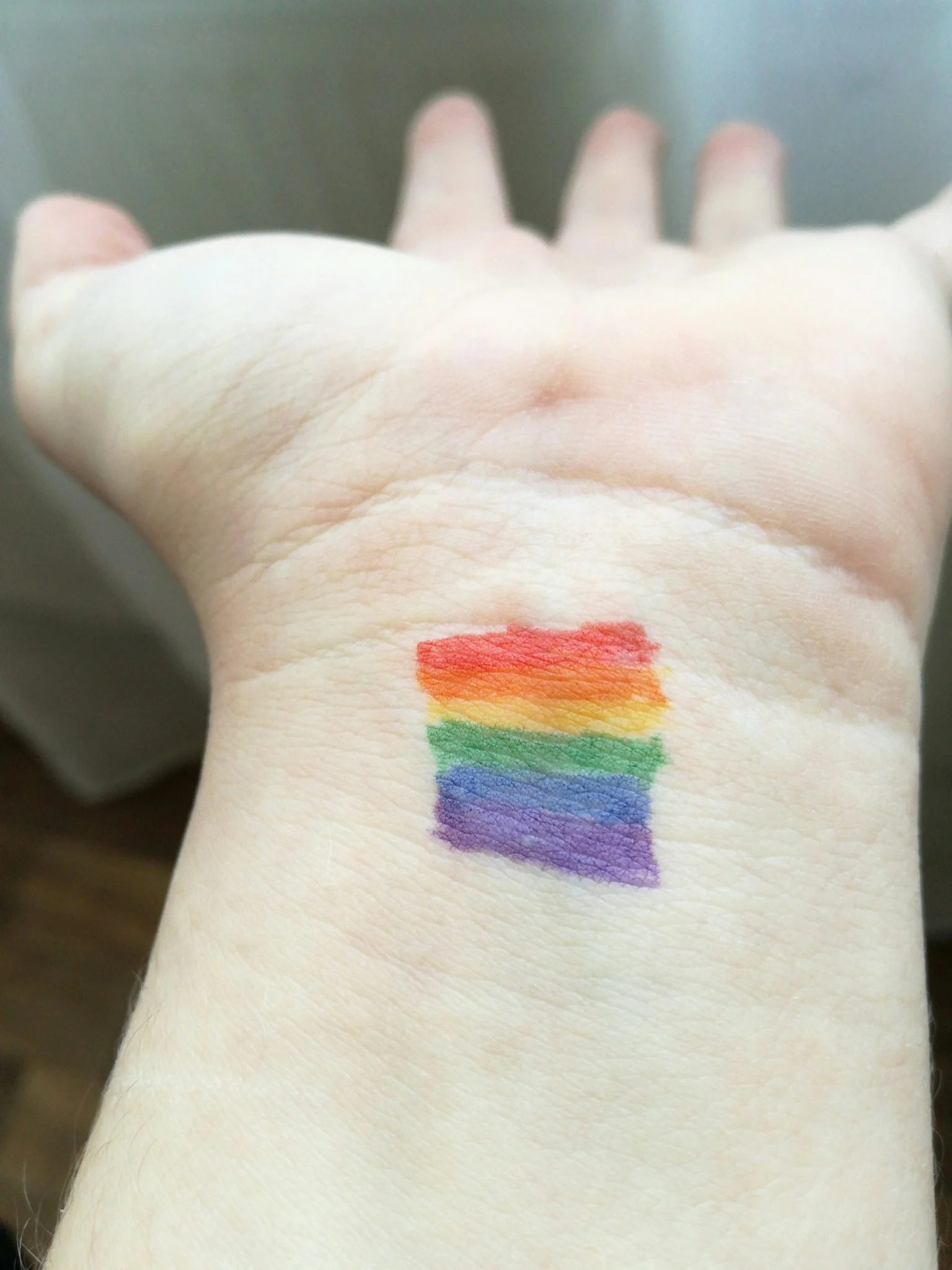 Een regenboog geschilderd op een handpalm.