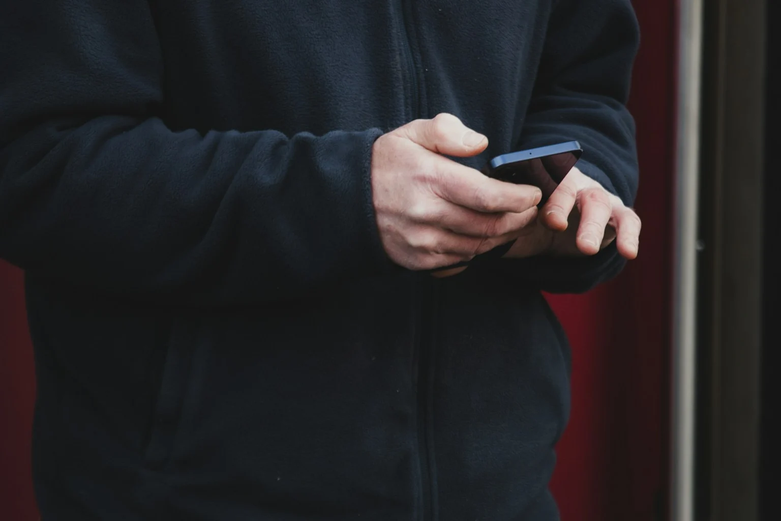 Handen bedienen een smartphone.